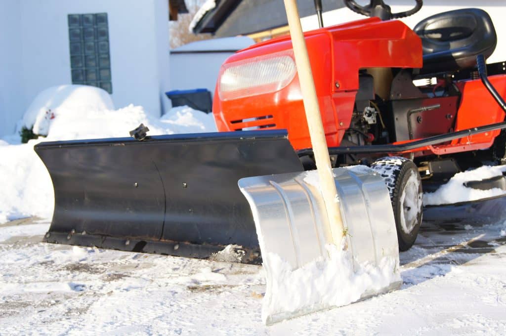 Winterdienst mit kleinem Traktor und Schneeschaufel